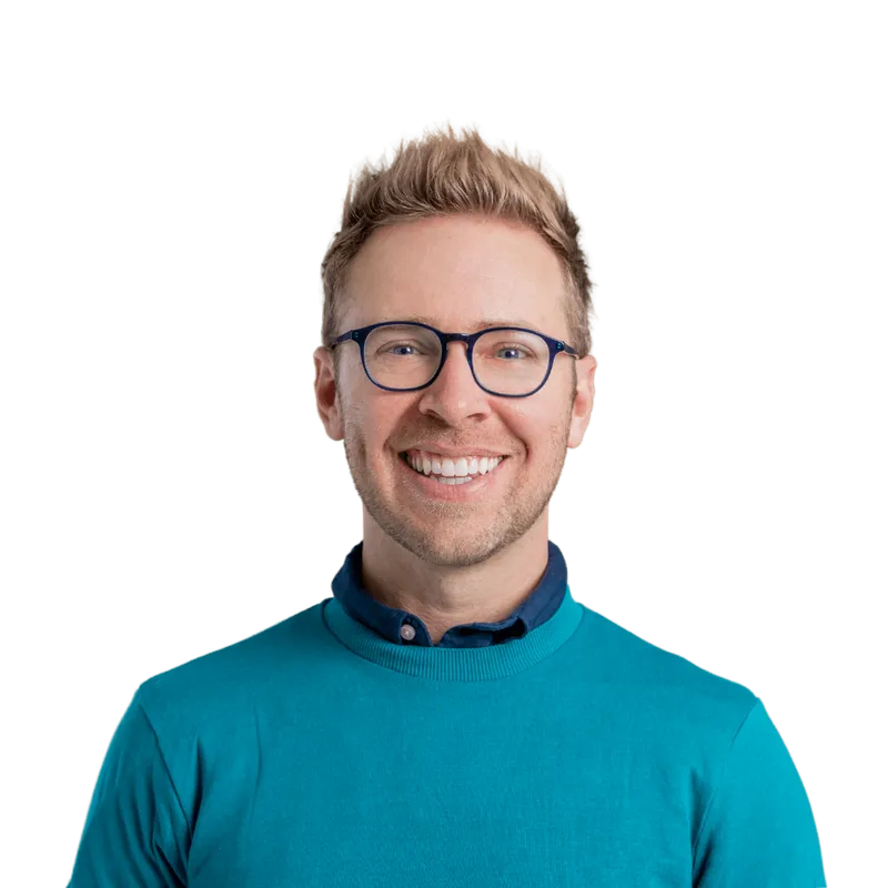 Nick Gray smiling, in glasses and a teal sweater